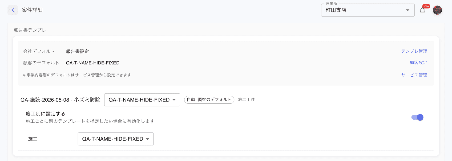 案件詳細の報告書設定ドロワー。上段に「会社デフォルト: 報告書設定」「顧客のデフォルト: QA-T-NAME-HIDE-FIXED」の階層表示、右側にテンプレ管理・顧客設定・サービス管理のリンク。下段に施工一覧 (QA-施設-2026-05-08 - ネズミ防除、自動: 顧客のデフォルトバッジ、施工 1 件) と「施工別に設定する」トグル (オン)、その下に「施工」ドロップダウンで QA-T-NAME-HIDE-FIXED が選択されている